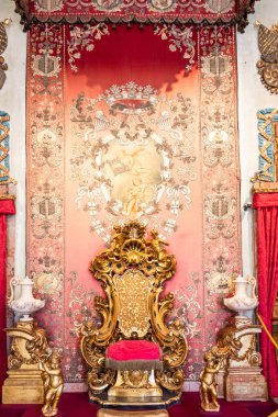 Isola Bella, İtalya - 1 Ağustos 2023: Antik altın ve kırmızı kadife taht. Eski kraliyet koltuğu, lüks mahsuller.