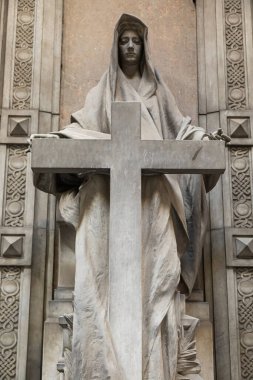 Mezarlıkta haçlı eski bir heykel. Dramatik gizemli figür, insan yok.