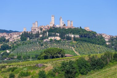 San Gimignano köyü, İtalya - yeşil kırsal bölge, mavi gökyüzü, şehir ve kuleleri olan tepe manzarası
