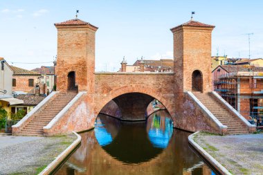 Comacchio, İtalya - 11 Haziran 2024: İtalyan kentinin tarihi sembolü ünlü Trepponti köprüsü. Liman manzarası