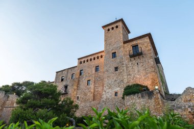 TARRAGONA, SPAIN - AUGUST 6, 2022: Low-angle view of the stone castle of Tamarit by the sea in Altafulla, Tarragona, at dusk.