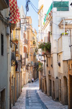 TARRAGONA, SPAIN - AUGUST 6, 2022: Narrow street in the old town of Tarragona, a tourist port city by the Mediterranean Sea in the northeast of Spain.