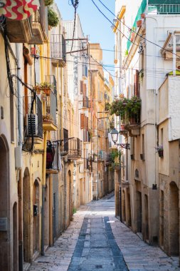 Empty narrow street in the old town of Tarragona, a tourist port city by the Mediterranean Sea in the northeast of Spain.