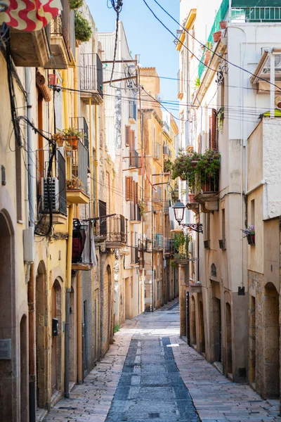 Empty narrow street in the old town of Tarragona, a tourist port city by the Mediterranean Sea in the northeast of Spain.