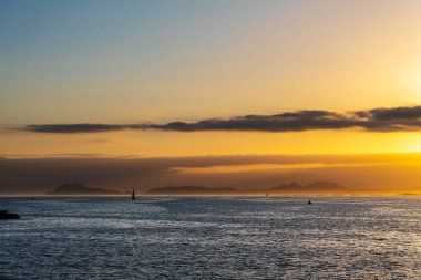 Günbatımında Galiçya 'da Ria de Vigo' da tekne gezintisi, arka planda Cies Adaları..