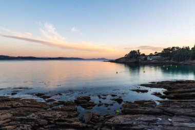 Galiçya kıyılarının silueti Ria de Pontevedra alacakaranlığının açılışında, arka planda Cies adaları ile.