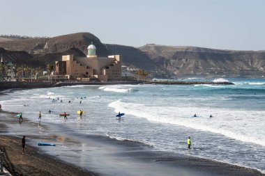 Büyük Kanarya, İspanya - 12 Aralık 2023: Sörfçüler, İspanya 'nın Kanarya Adaları' ndaki Las Palmas de Gran Kanarya Sahili 'ndeki La Cicer plajında (Las Canteras) dalgaların tadını çıkarıyorlar..