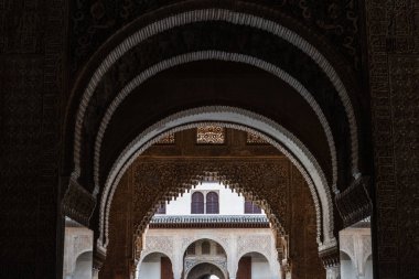 24 Mart 2023, Granada, İspanya 'daki Alhambra Sarayı' nın içindeki kemer ve duvarların süslemeleriyle ışıklar ve gölgeler oynuyor..