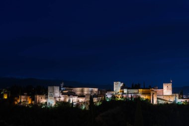 24 Mart 2023: Granada 'daki Alhambra Panorama manzarası açık bir bahar gecesi, İslam mimarisinin en ünlü anıtlarından biri olan bir saray ve kale kompleksi.