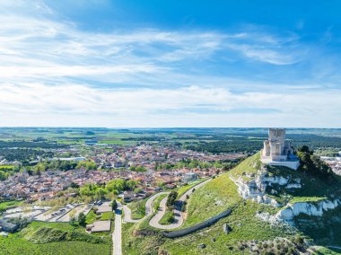 Günbatımında Valladolid 'deki ünlü Penafiel şatosunun hava manzarası, arka planda eski köy ve şarap mahzenleri var..