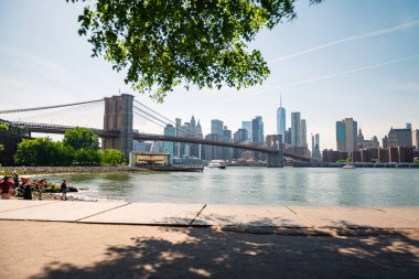 Brooklyn Köprüsü 'nün ve New York' un doğu nehrinin karşısındaki Pebble Sahili 'nden gökyüzünün uzun pozlu görüntüleri..