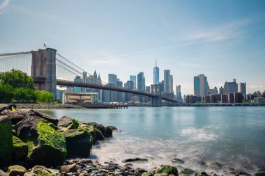 Brooklyn Köprüsü 'nün ve New York' un doğu nehrinin karşısındaki Pebble Sahili 'nden gökyüzünün uzun pozlu görüntüleri..
