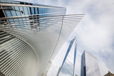 NEW YORK CITY - 18 Mayıs 2024: Oculus 'un modern mimarisi ve Aşağı Manhattan, New York' taki Dünya Ticaret Merkezi 'nin düşük açılı görüşü. Bu çarpıcı perspektif, Oculus ve yüksek prese 'nin parlak, fütürist tasarımını vurgular.