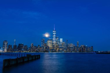 Manhattan siluetinin uzun bir görüntüsü Hoboken, New Jersey 'den alacakaranlıkta görülüyor..