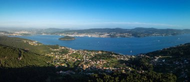 İspanya 'nın Galiçya bölgesindeki Ria de Pontevedra boyunca uzanan kumsalların ve büyüleyici küçük köylerin havadan görünüşü. Bu görkemli manzara çarpıcı kıyı şeridini, yemyeşil suları ve sakin suları gösteriyor, doğal güzelliği ve dingin atmosferi yakalıyor.
