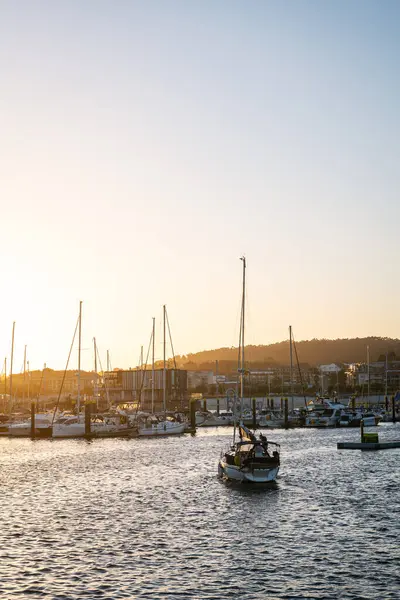 stock image SANXENXO, SPAIN - AUGUST 13, 2023: Small boats moored in the yacht club of Portonovo (Pontevedra, Spain) on a sunny Summer day, with a small sailboat entering the port.