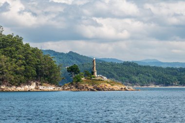 İspanya, Galiçya 'daki Ria de Pontevedra' da bir tekneden görüldüğü gibi Tambo Adası 'nın deniz feneri. 2022 'den beri doğal ve kültürel bir hedef olarak hizmet vermektedir..