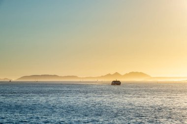 Akşam üzeri Galiçya 'da Ria de Vigo' da feribot var. Arka planda Cies Adaları var..