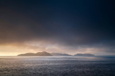 Fırtınalı bir yaz öğleden sonrasında İspanya, Galiçya, Ria de Vigo 'daki Cies Adaları' nın silueti. Pontevedra açıklarındaki bu dramatik adalar 1980 yılında Doğa Koruma Alanı ilan edildi ve Galiçya Ulusal Parkı 'nın Atlantik Adaları' nın bir parçasıdır.