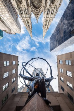 NEW YORK CITY - 25 Mayıs 2024: Manhattan, New York 'taki Atlas Heykeli ve St. Patrick Katedrali' nin alçak açılı görüntüsü.