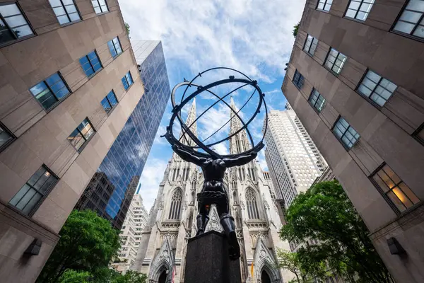 NEW YORK CITY - 25 Mayıs 2024: Manhattan, New York 'taki Atlas Heykeli ve St. Patrick Katedrali' nin alçak açılı görüntüsü.