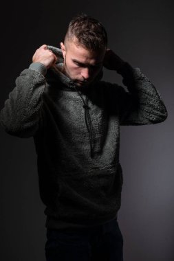 Genç endişeli bir adam, stüdyo portresi, koyu gri arka plan