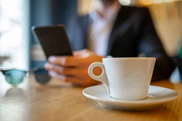 Adamı Sabah Kahvesini Büyük Beyaz Bardaktan Içiyor Cep Telefonundan Haber — Stok fotoğraf