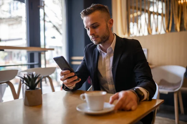 Φοβερός Νεαρός Επιχειρηματίας Διαβάζει Ειδήσεις Στο Smartphone Και Πίνοντας Πρωινό — Φωτογραφία Αρχείου
