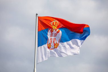 Sırp ulusal bayrağı rüzgar, açık hava ve bulutlu arka planda