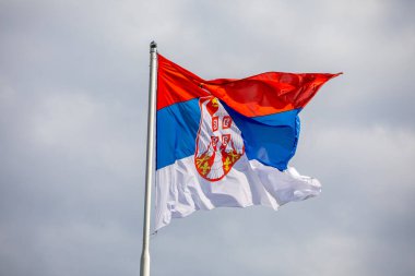 Sırp ulusal bayrağı rüzgar, açık hava ve bulutlu arka planda