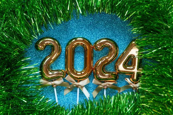 新年快乐2024 灿烂的背景照片上的橙色金色数字 图库图片