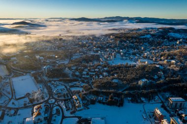 Zlatibor kasabasının panoramik hava manzarası ve Zlatibor Dağı üzerindeki alçak bulut kış günbatımında, Sırbistan 'ın Cajetina kentinde.