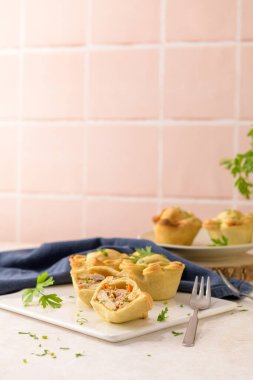 Tavuklu turtalar ve maydanoz yaprakları mutfak tezgahında beyaz seramik tabaklarda.