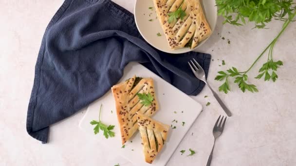 在厨房柜台顶上的白色陶瓷盘上 有意大利乳酪和欧芹叶的菠菜泡糕点 — 图库视频影像