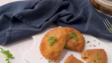 Et köfteleri ve maydanoz yaprakları mutfak tezgahındaki beyaz seramik tabaklarda..