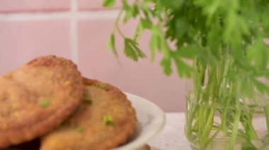 Et köfteleri ve maydanoz yaprakları mutfak tezgahındaki beyaz seramik tabaklarda..