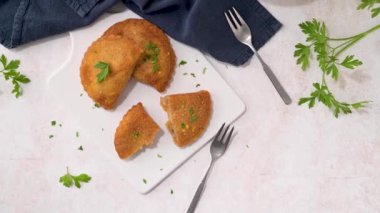 Et köfteleri ve maydanoz yaprakları mutfak tezgahındaki beyaz seramik tabaklarda..
