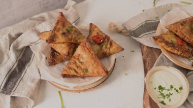 Hint samosaları - kızarmış ya da fırında hamur tatlısı ve baharatlı mutfak tezgahında areca yaprağı tabağında servis edilen lezzetli Hint yemekleri..