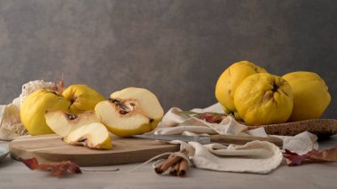 Olgun sarı ayvaları veya Kraliçe elma meyve ve zanaat mantar levha rustik siyah arka plan üzerine tohum ile dilimlenmiş Ayva tatlısı.