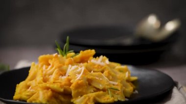 Koyu taştan mutfak tezgahında seramik tabakta kabak soslu Farfalle makarna..