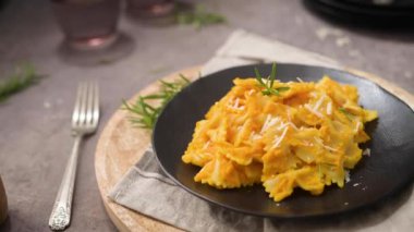 Koyu taştan mutfak tezgahında seramik tabakta kabak soslu Farfalle makarna..