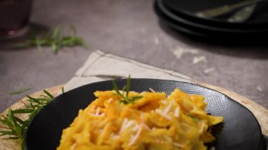 Koyu taştan mutfak tezgahında seramik tabakta kabak soslu Farfalle makarna..