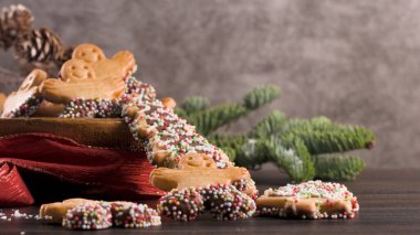 Noel tatil arka plan gingerbread çerezleri, şekerler ve herdem yeşil ahşap masa üzerinde. Noel ve yeni yıl yiyecek. Noel dekorasyonu ve tatlılar ahşap arka plan üzerinde.