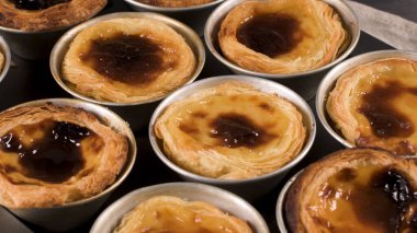 Satırları yeni pişirilmiş yumurta tart, geleneksel Portekiz tatlı, pastel de nata, kremalı tart metal tepsi.