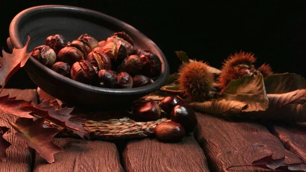 Geröstete Kastanien Auf Einem Rustikalen Holztisch Mit Herbstblättern Hintergrund — Stockfoto