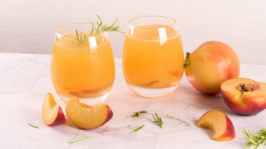 Ev yapımı şeftali suyu buz küpleri ve biberiye ile cam mermer taş zemin üzerine bırakır..