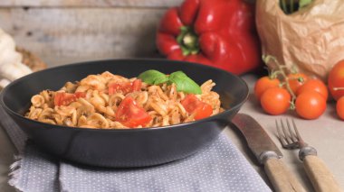 Ton balığı ve fesleğen ile İtalyan makarna. Eski ahşap arka plan üzerinde ton balığı ve domates soslu makarna.