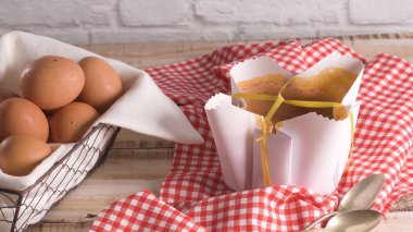 Portekizce pandispanya, ahşap arka plan üzerinde pişirme üzerinde tipik kağıda sarılı.