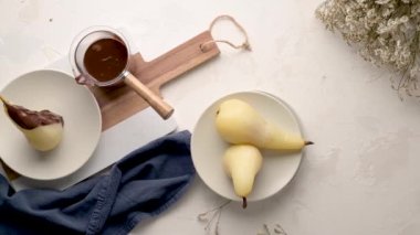 Poire Belle Helene - armuttan yapılmış Fransız tatlısı çikolatalı ganache ile servis ediliyor.