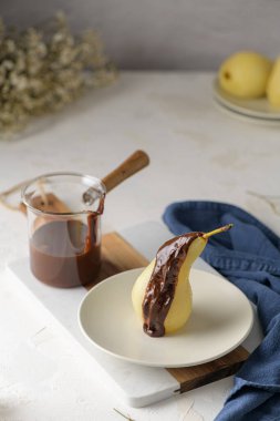 Poire Belle Helene - armuttan yapılmış Fransız tatlısı çikolatalı ganache ile servis ediliyor.